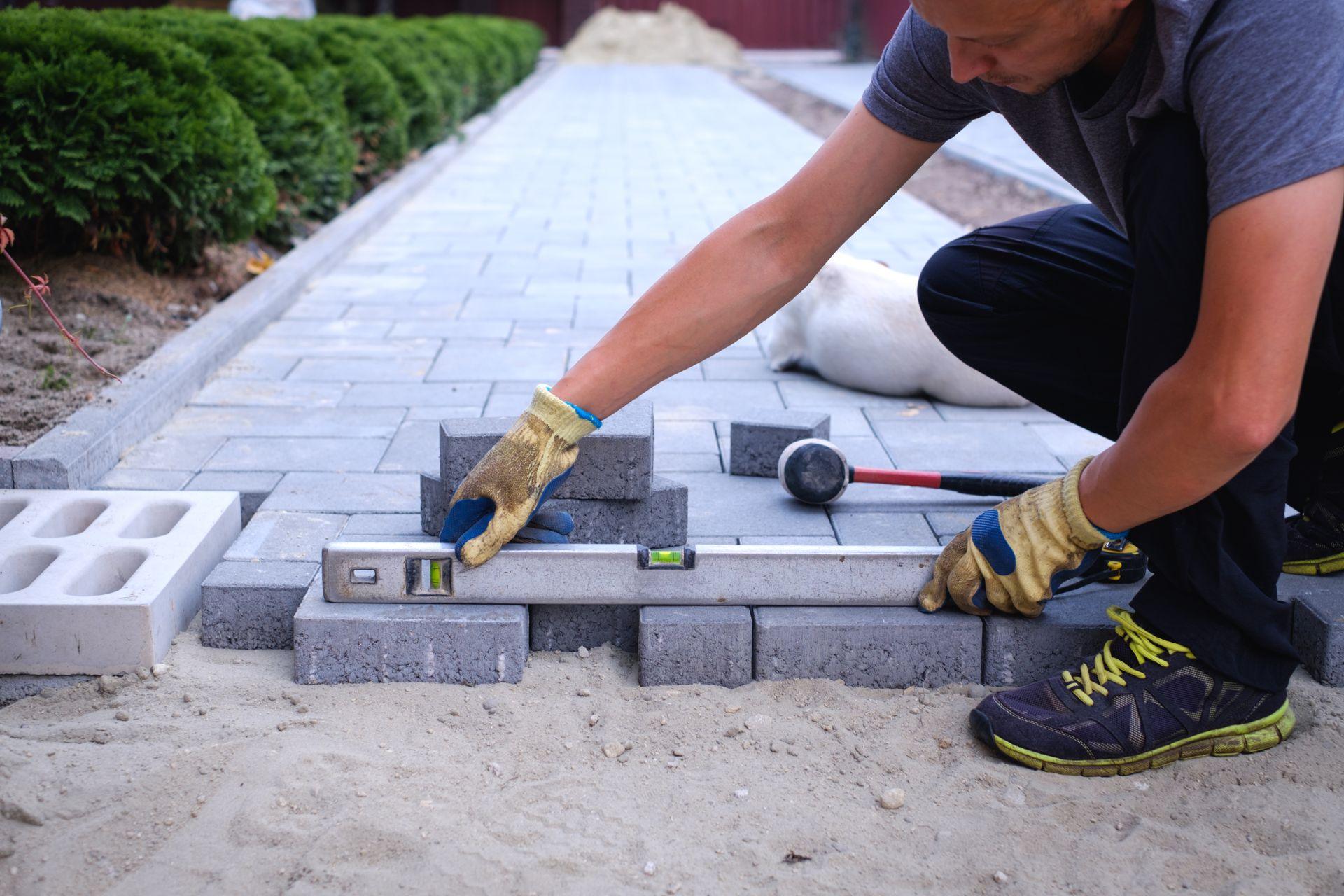 Stratenmaker legt betonklinkers voor een tuinpad