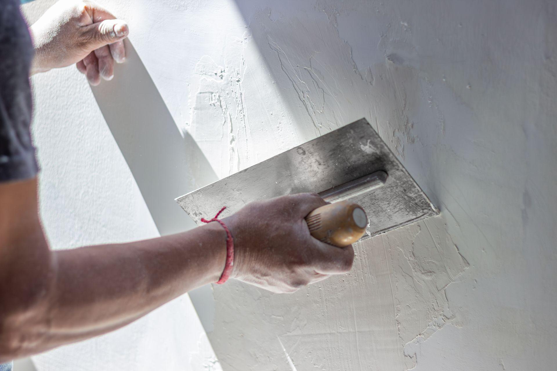 Stukadoor werkt een wand glad af met een spaan